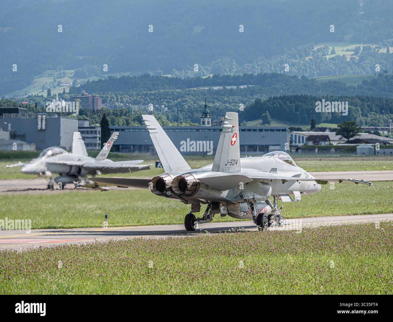 Schweizer Luftwaffe F-18 Jet landet und bewegt auf der Landebahn. Das Kampfflugzeug verlangsamt sich nach dem Aufsetzen und bewegt sich auf dem Rollweg mit Präzision d Stockfoto