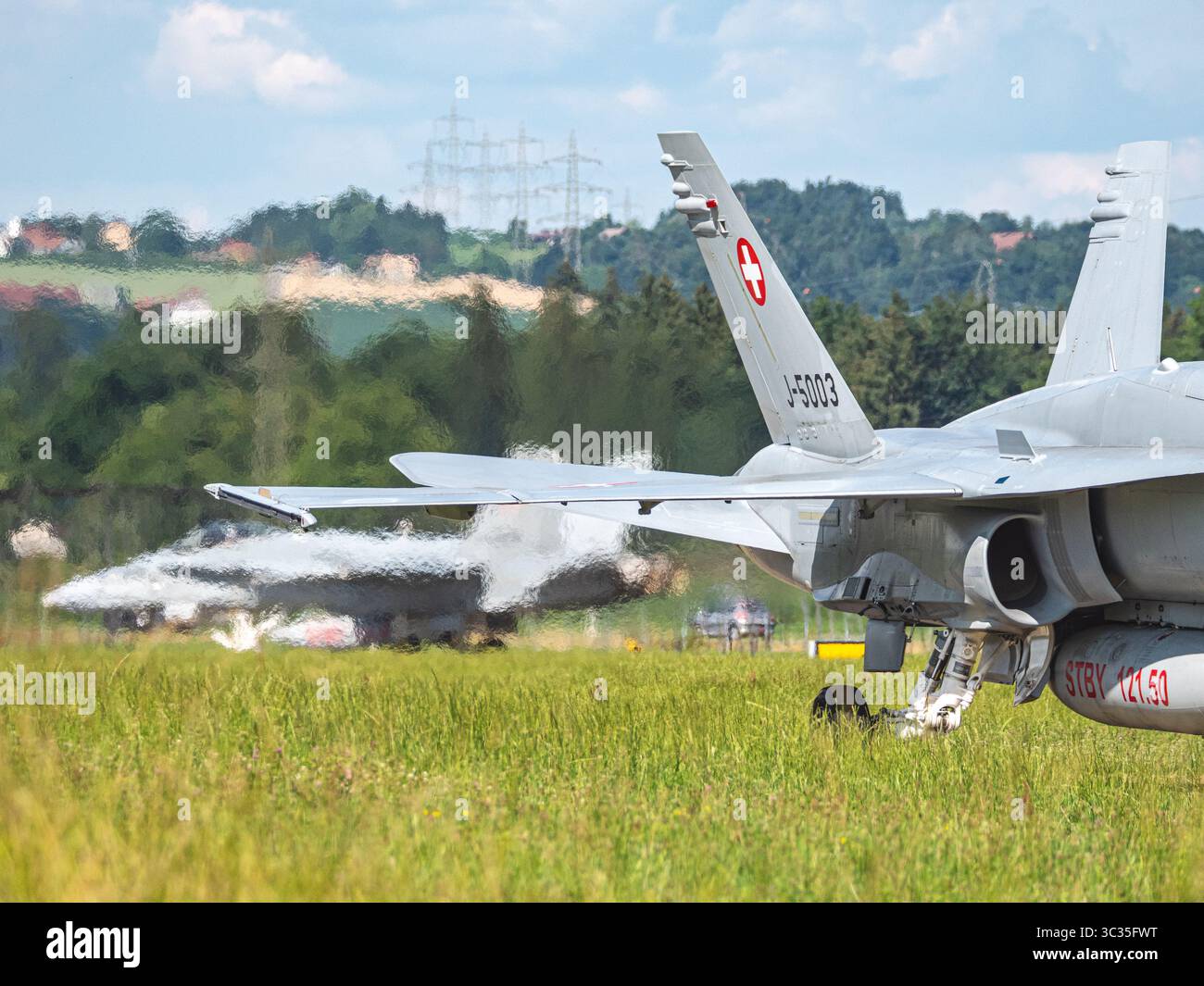 Schweizer Luftwaffe F-18 Jet landet und bewegt auf der Landebahn. Das Kampfflugzeug verlangsamt sich nach dem Aufsetzen und bewegt sich auf dem Rollweg mit Präzision d Stockfoto
