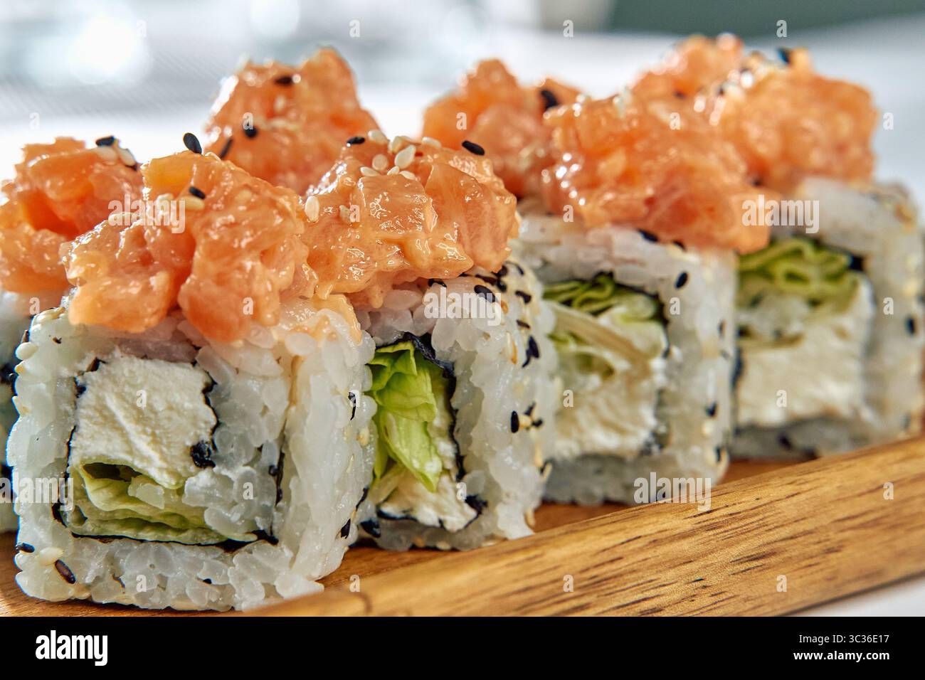 Eine köstliche Platte mit frischen Sushi Rolls garniert mit herzhaftem Lachs und knusprigem Gemüse, perfekt für kulinarische Genüsse und kulinarische Köstlichkeiten Stockfoto