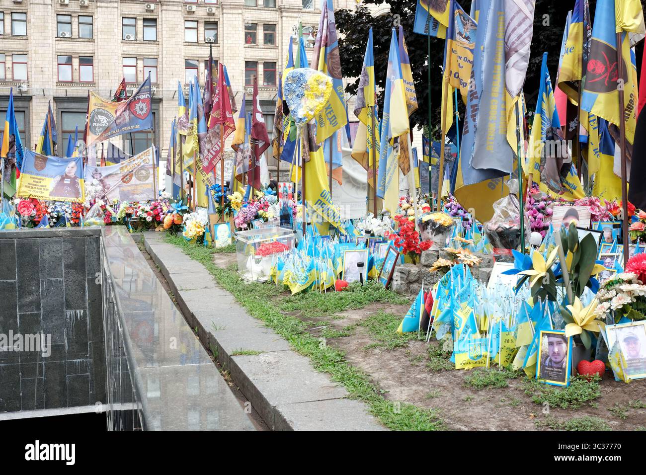 Blumen, Fahnen und Fotos ehren tapfere Soldaten an der Gedenkstätte. Stockfoto
