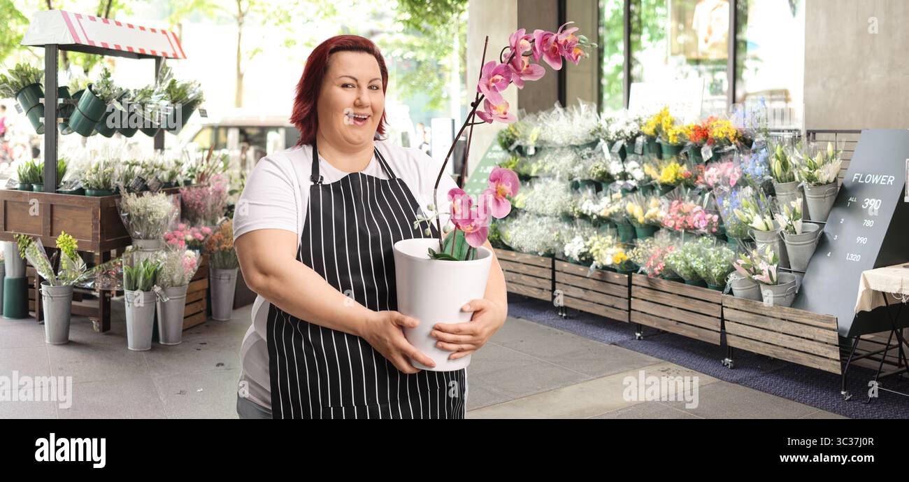 Frau, die Orchideen in einem Blumenladen verkauft Stockfoto