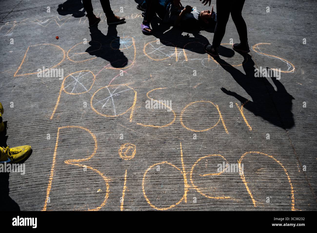6. April 2021, Tijuana, Mexiko: Kinder schreiben in Kreide „Dejenos Pasar Biden“ auf der Straße, wo das Chaparral Camp in Tijuana weiter wächst. (Bild: © Raquel Natalicchio/ZUMA Wire) Stockfoto