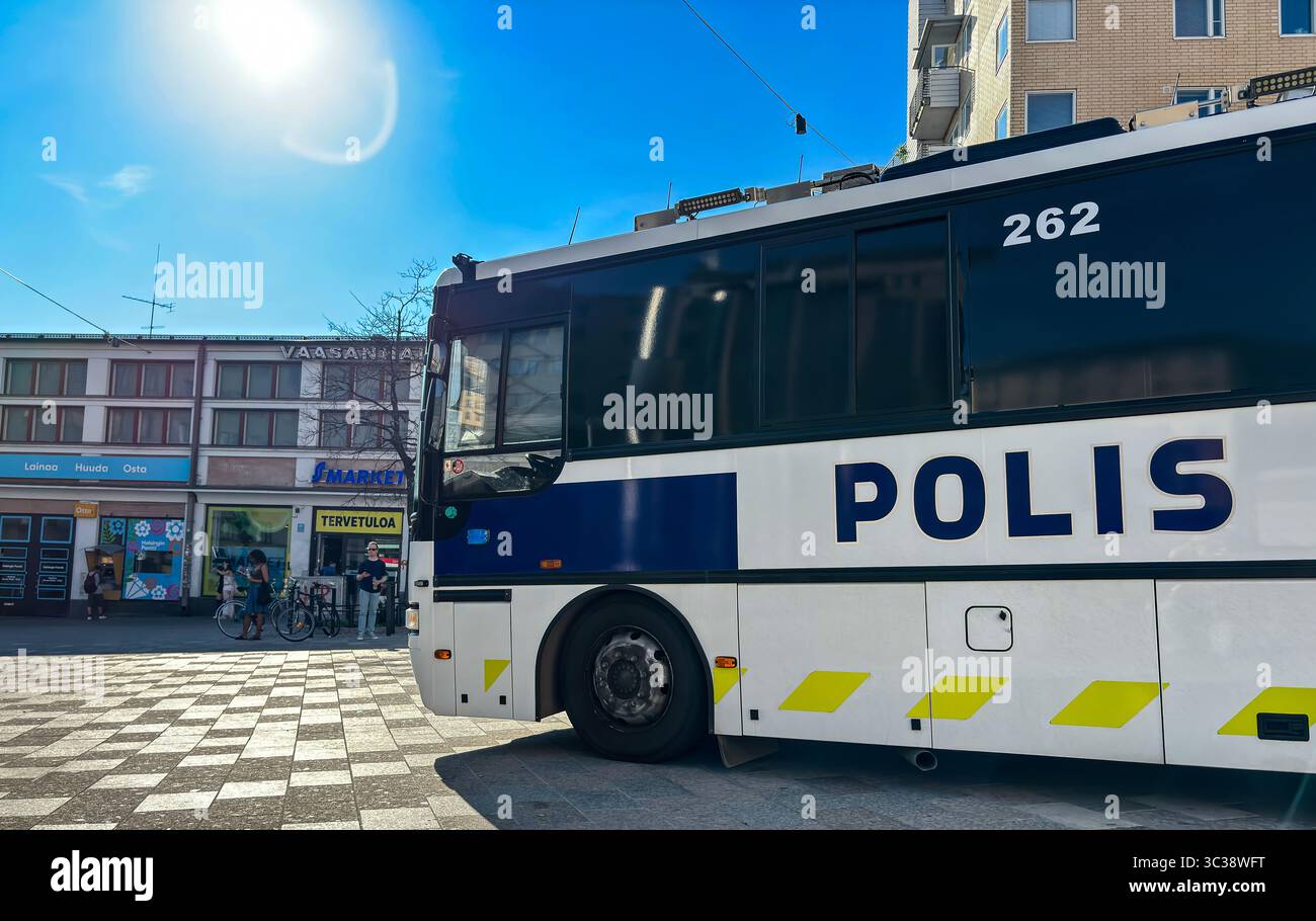 Ein Polizeibus der Helsinki-Polizei in Vaasanpuistikko an einem Sommerabend. Im Hintergrund das Gewerbegrundstück Vaasanhalli. - Smartphone-aufgenommenes Stockfoto
