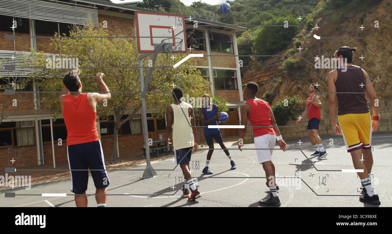 Schießender Spieler, der einen Schuss mit Teamkollegen abgibt, die sich auf dem Schulplatz bewegen, mit Reifen und Hügeln Stockfoto