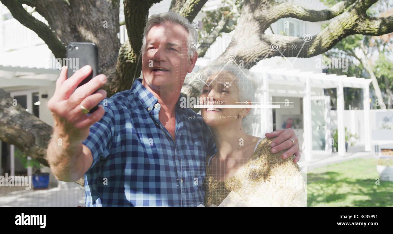 Selfie, Pullover-bekleidete Frau und karierter Mann unter Eiche im Garten, mit Smartphone Stockfoto