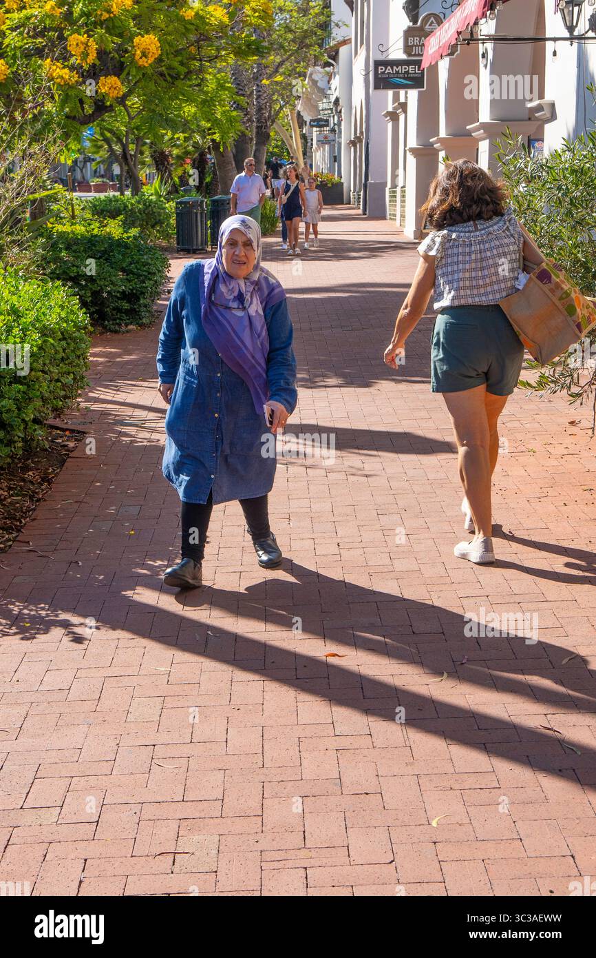 Ältere behinderte Moslim-Frau, die in Santa Barbara, Kalifornien, in die Innenstadt läuft. Stockfoto