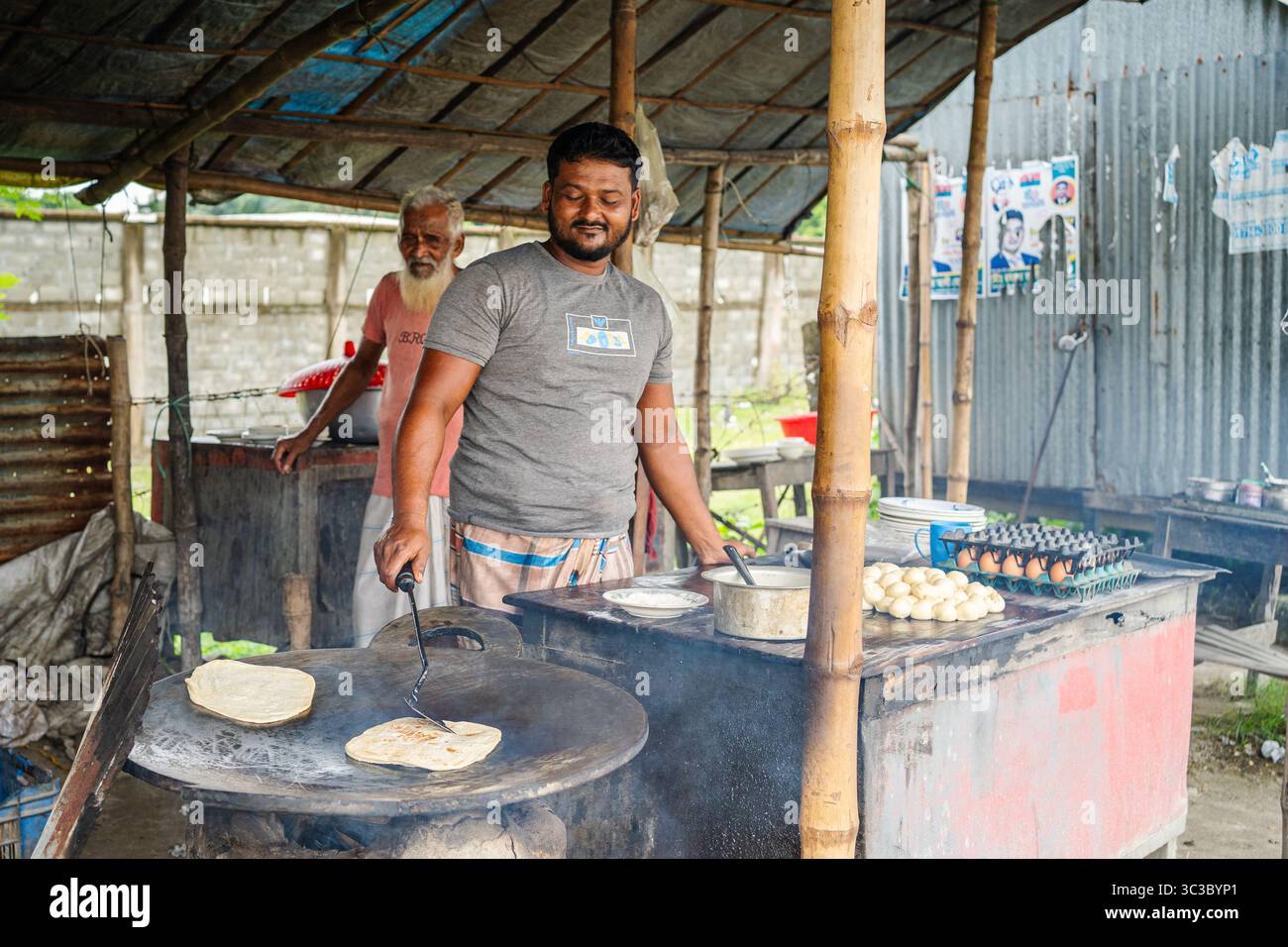 Lokale Bangladeshi Shefs bereiten in einem traditionellen Restaurant Speisen zu Stockfoto