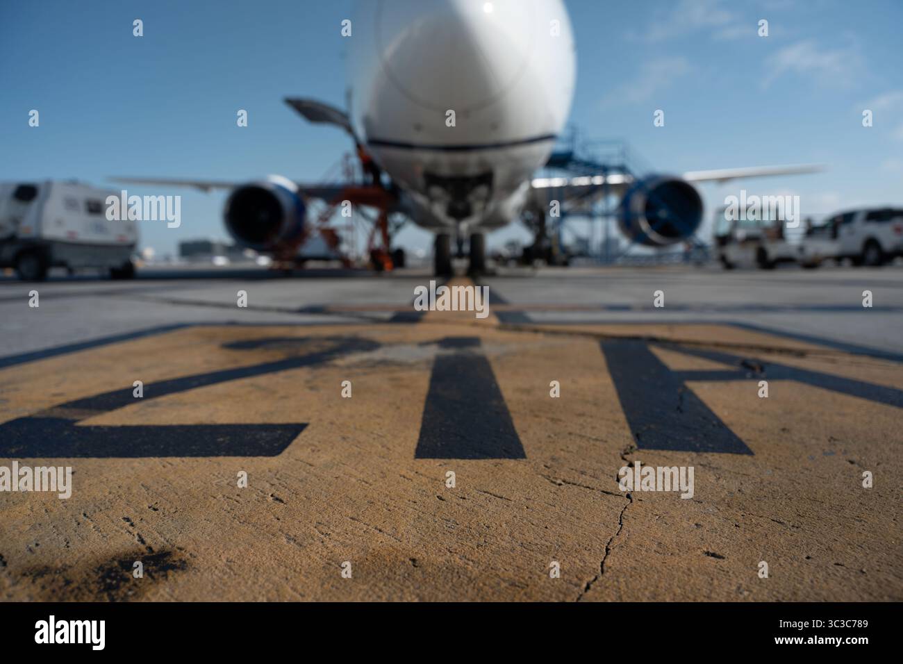 Bodenmarkierung am Flughafen, die zu einem Verkehrsflugzeug führt, das während der Wartungsarbeiten im Freien abgestellt wird. Stockfoto
