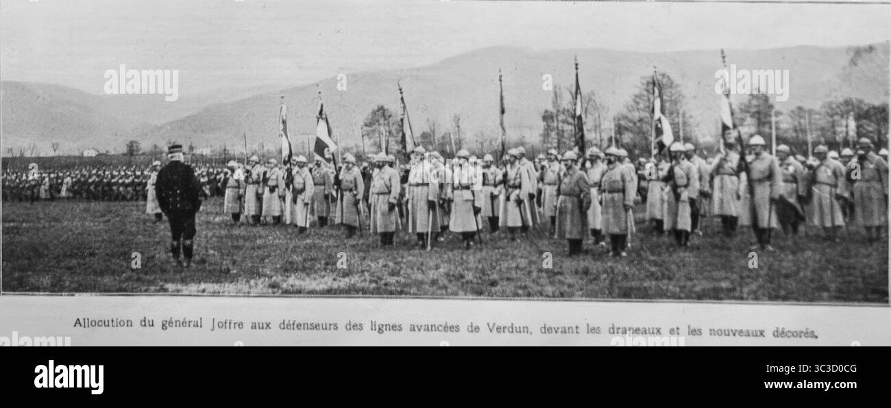 General Joseph Joffre spricht dekorierte französische Soldaten und Farbträger der Frontverteidiger Verdun an, wie sie am 25. März 1916 in LíIllustration veröffentlicht wurden. Diese militärische Zeremonie fand in einem entscheidenden Moment in der Schlacht von Verdun statt. Vor den General- und Regimentsflaggen stehen Reihen von Truppen vor einem Hintergrund von Hügeln und Bäumen. Historisches Bild der französischen Armee aus dem Ersten Weltkrieg Stockfoto