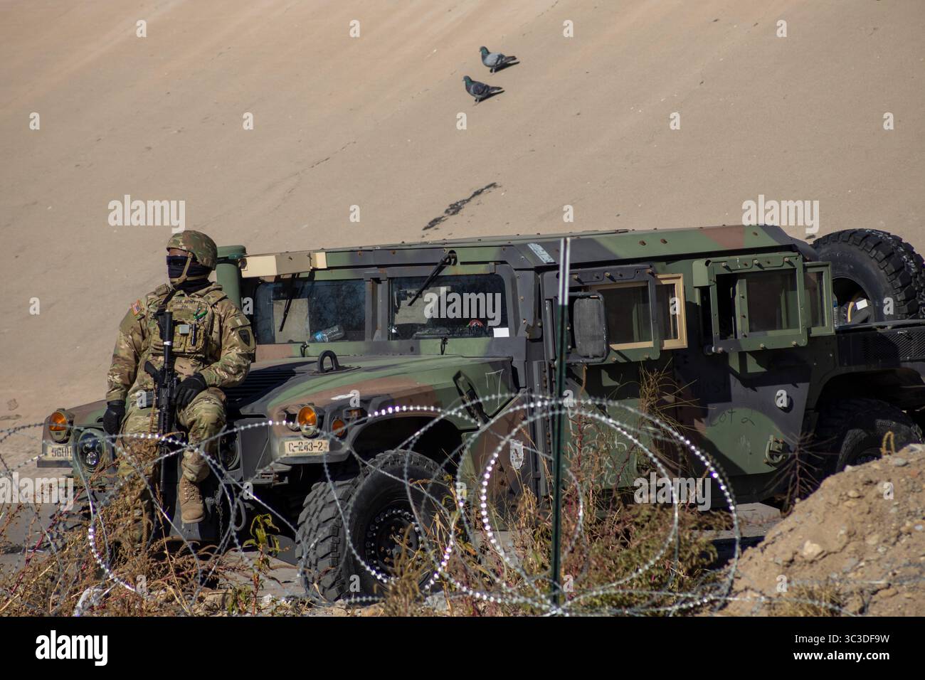 Ein Soldat in Tarnung bewacht ein Militärfahrzeug in der Nähe von Ciudad Juarez und überwacht die Grenzsicherheit. Stockfoto