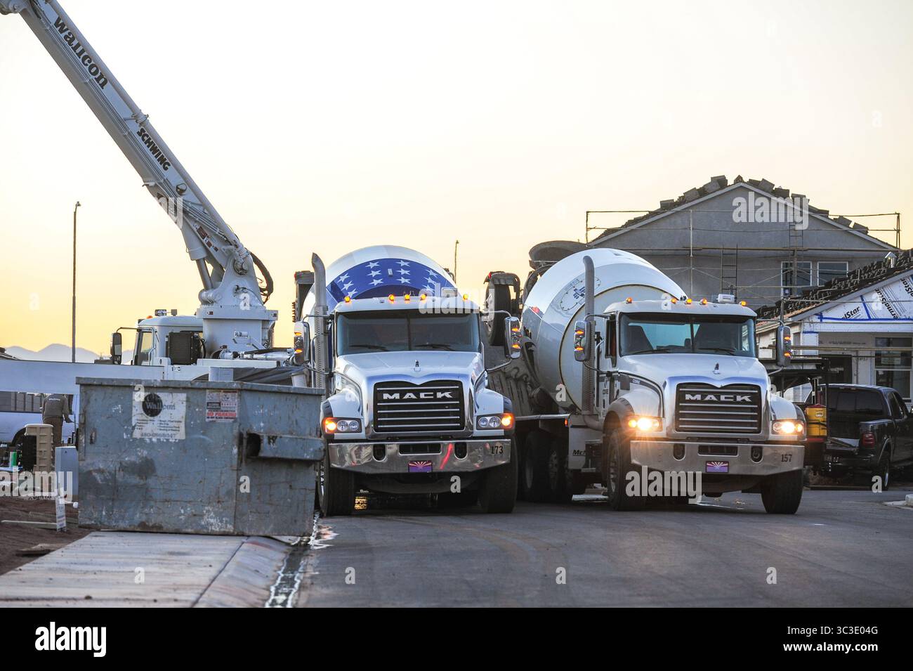 Apache Junction, Arizona, USA. Juli 2025. Betonmischer säumen eine Wohnstraße in einer neuen Unterteilung, die bei Sonnenaufgang in Apache Junction gebaut wird. Pinal County verwandelt sich schnell in ein Wirtschaftskraftwerk zwischen Phoenix und Tucson, das ländliche Wurzeln mit modernem Wachstum verbindet. Städte wie Casa Grande, Apache Junction, Queen Creek und Superior treiben diesen Wandel durch strategische Infrastruktur, Industrie und Wohnungsentwicklung voran. (Kreditbild: © Eduardo Barraza/ZUMA Press Wire) NUR REDAKTIONELLE VERWENDUNG! Nicht für kommerzielle ZWECKE! Stockfoto