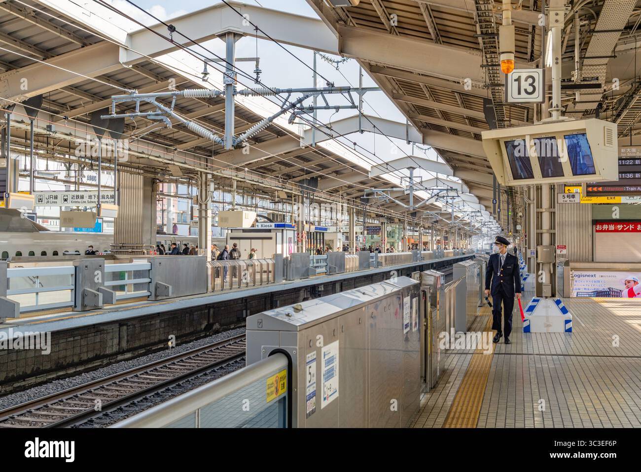 Tokio, Japan - 15. Januar 2025 Eisenbahnarbeiter in Uniform wartet auf Shinkansen-Hochgeschwindigkeitszug im Bahnhof. Stockfoto