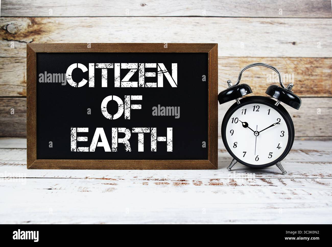 Bürger der Erde Textnachricht und Wecker auf hölzernem Hintergrund Stockfoto