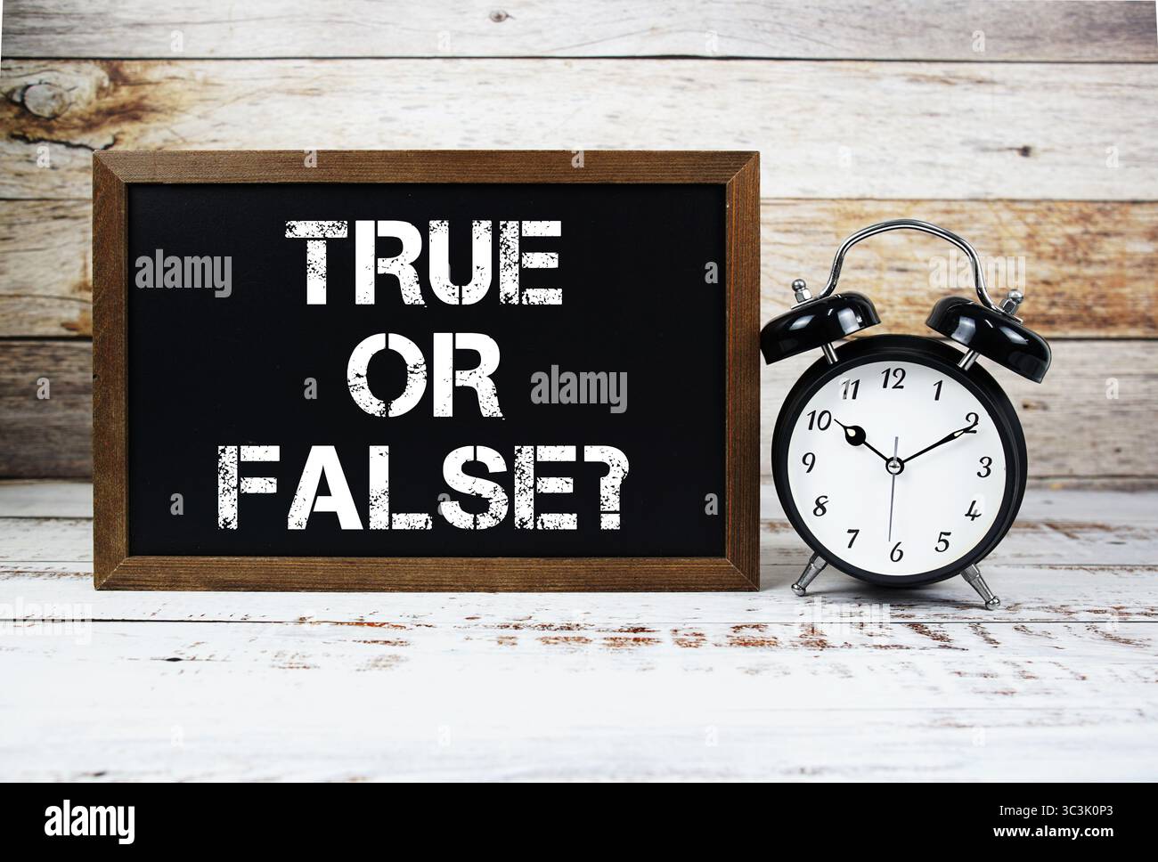 Richtig Oder Falsch? Textnachricht und Wecker auf hölzernem Hintergrund Stockfoto