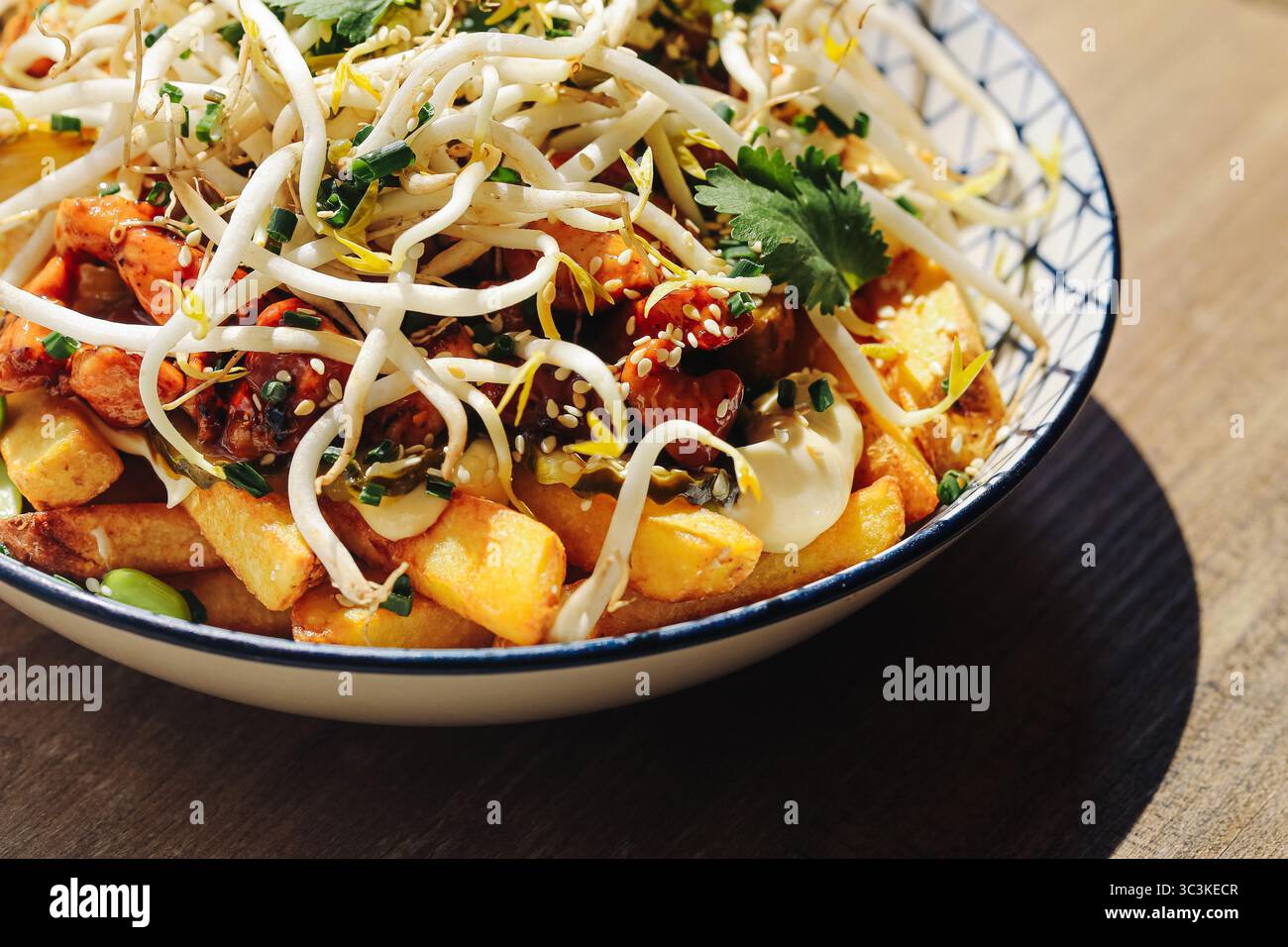 Asiatisches Essen mit Sprossen. Buntes Gericht in einer Schüssel mit Gemüse und Sauce. Frische Zutaten und Kräuter. Traditionelle gesunde Mahlzeit. Orientalische Küche. Stockfoto