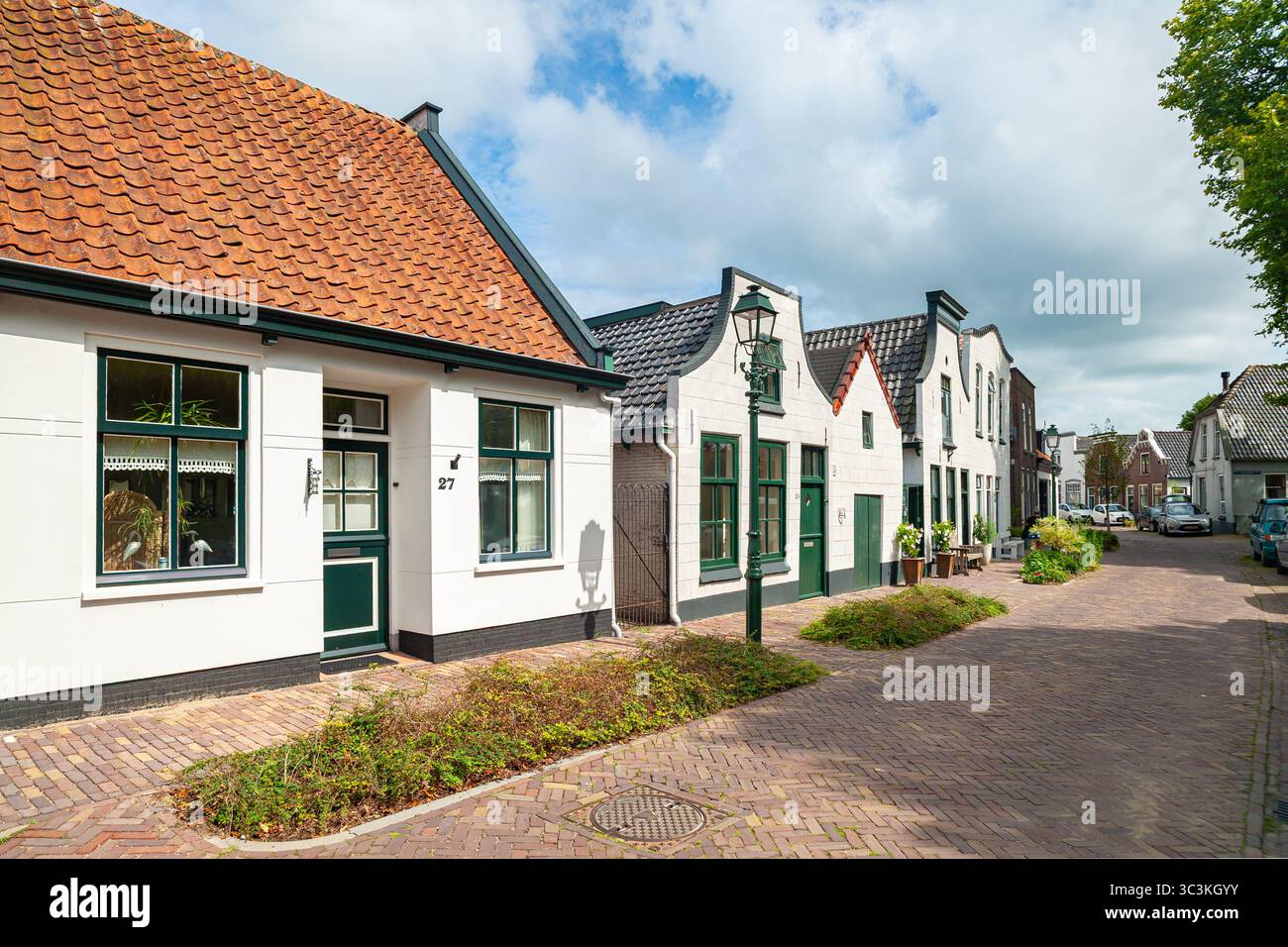 Charmante Straße mit historischen Häusern mit orangefarbenen Dächern und grünen Türen Stockfoto
