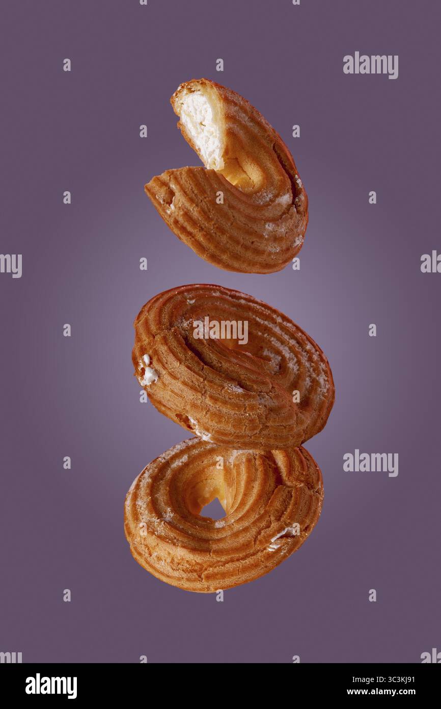 Süße Bagels wirbeln vor einer Hintergrundfarbe sehr peri Stockfoto