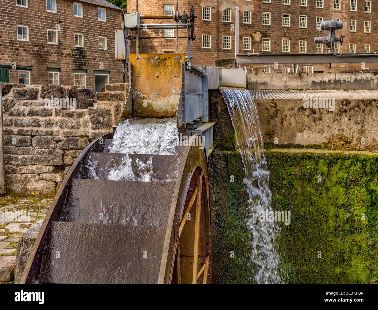 Neues Wasserrad bei Cromford Mills in Derbyshire, Großbritannien, das zusammen mit einer 17-kWh-Wasserturbine und einem Heizsystem für Wasserquellen 20 % der... Stockfoto