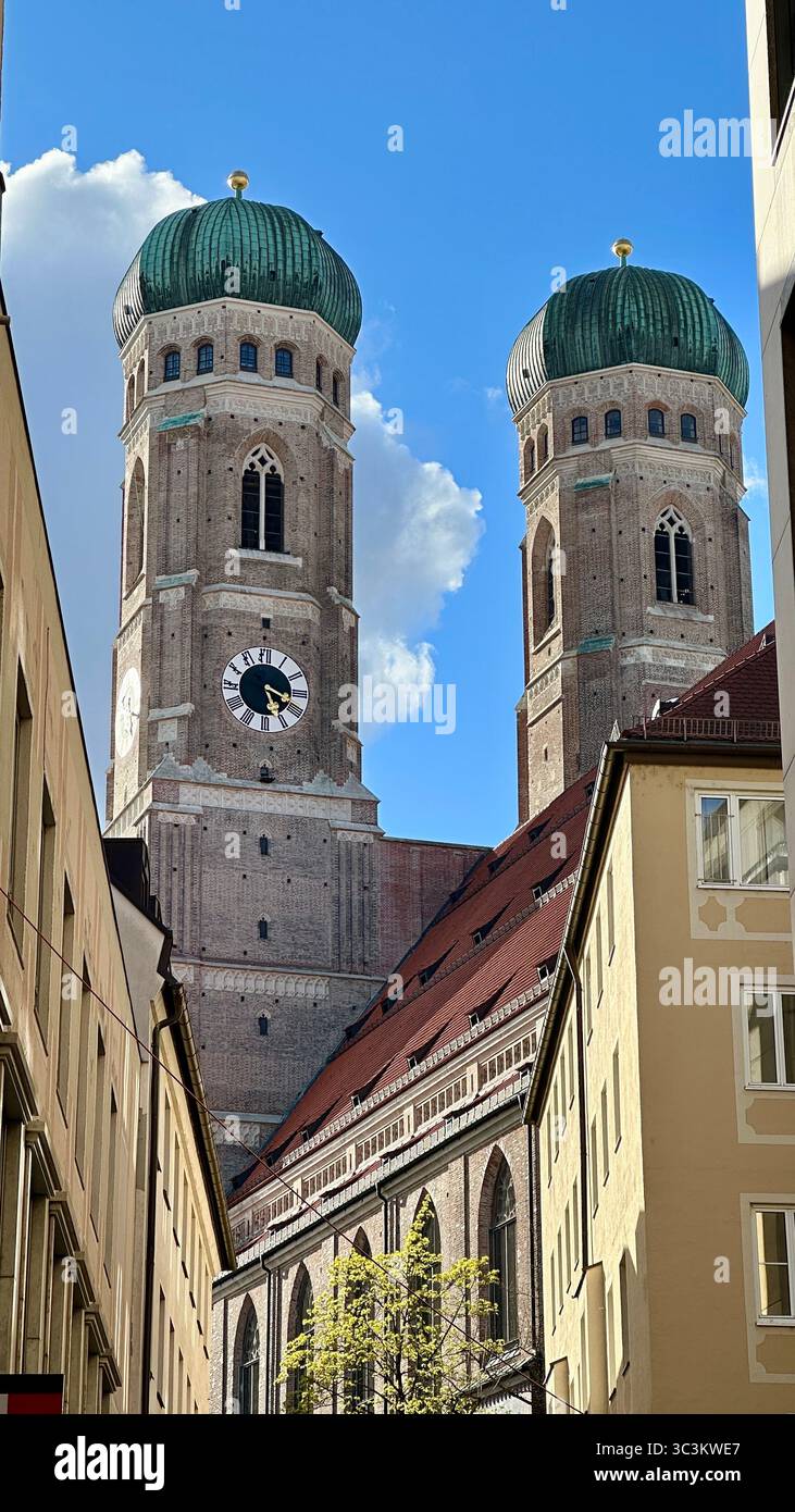 Die zwei Kuppeltürme der Frauenkirche erheben sich markant über historischen Dächern im Zentrum von München, Bayern, Deutschland, Stockfoto