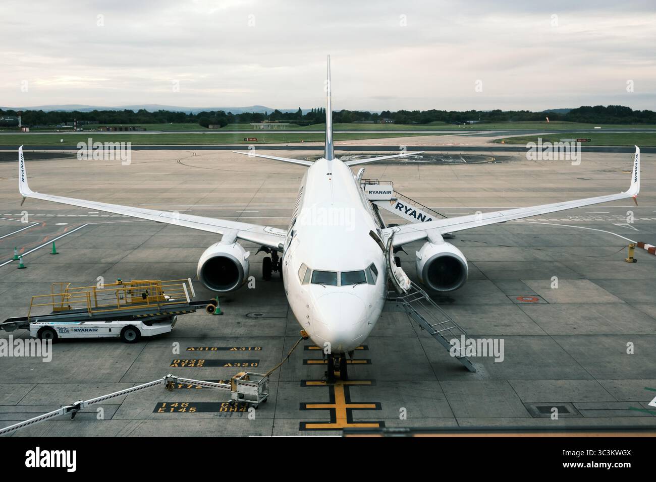 Eine Ryanair Boeing 737 auf dem Rollfeld am Flughafen Manchester, die auf das Einsteigen von Passagieren wartet. Stockfoto