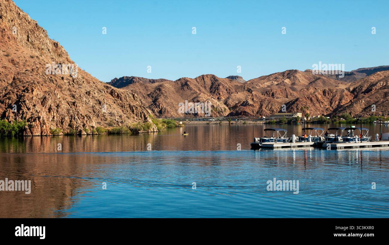 Blick auf die Berge, die sich im ruhigen Wasser des Colorado River unter klarem Himmel in Arizona spiegeln. Stockfoto