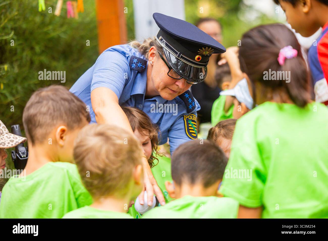 Presse- und Fototermin zur Verkehrssicherheit in der Kita Baumhaus die Dresdner Kita BAUMHAUS mit ihrem naturpädagogischen Schwerpunkt. Die gute Verkehrsanbindung birgt aber zum Teil komplexe Herausforderungen für die künftigen Schulkinder. Durch gezielte Übungen, Rollenspiele und gemeinsame Spaziergänge mit ihren Erzieherinnen und Erziehern können die Kinder ein Gefühl für sichere Verhaltensweisen im Straßenraum entwickeln. Einmal im Jahr bringen Bürgerpolizisten den Vorschulkindern die wichtigsten Verkehrsregeln auf spielerische Weise näher. Die Kinder wurden sensibilisiert, Gefahren m Stockfoto
