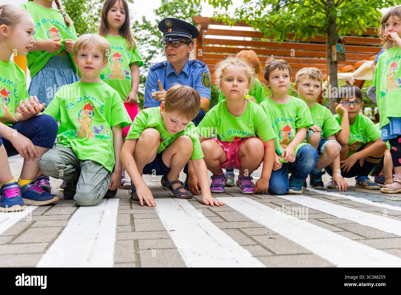Presse- und Fototermin zur Verkehrssicherheit in der Kita Baumhaus die Dresdner Kita BAUMHAUS mit ihrem naturpädagogischen Schwerpunkt. Die gute Verkehrsanbindung birgt aber zum Teil komplexe Herausforderungen für die künftigen Schulkinder. Durch gezielte Übungen, Rollenspiele und gemeinsame Spaziergänge mit ihren Erzieherinnen und Erziehern können die Kinder ein Gefühl für sichere Verhaltensweisen im Straßenraum entwickeln. Einmal im Jahr bringen Bürgerpolizisten den Vorschulkindern die wichtigsten Verkehrsregeln auf spielerische Weise näher. Die Kinder wurden sensibilisiert, Gefahren m Stockfoto