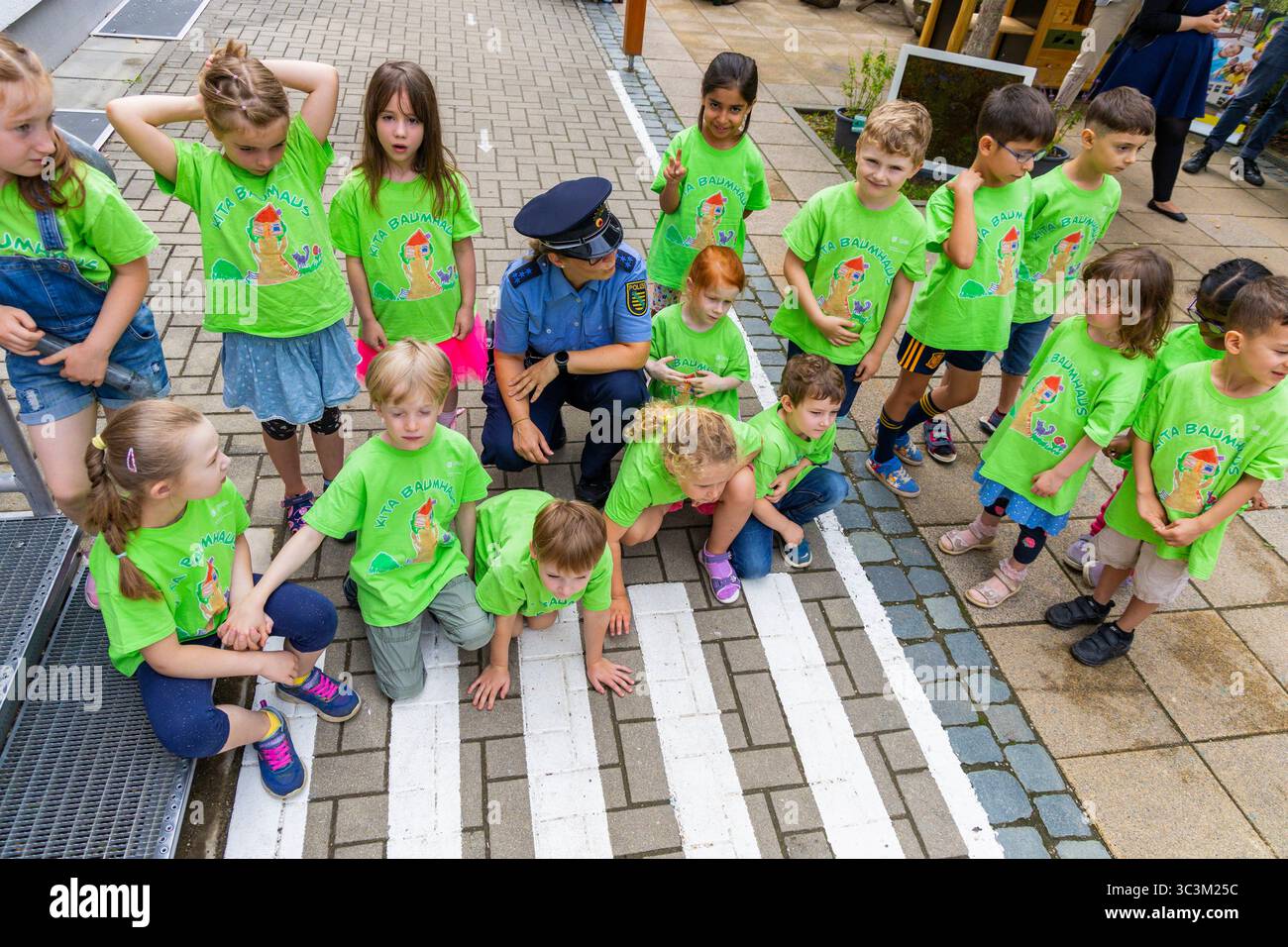 Presse- und Fototermin zur Verkehrssicherheit in der Kita Baumhaus die Dresdner Kita BAUMHAUS mit ihrem naturpädagogischen Schwerpunkt. Die gute Verkehrsanbindung birgt aber zum Teil komplexe Herausforderungen für die künftigen Schulkinder. Durch gezielte Übungen, Rollenspiele und gemeinsame Spaziergänge mit ihren Erzieherinnen und Erziehern können die Kinder ein Gefühl für sichere Verhaltensweisen im Straßenraum entwickeln. Einmal im Jahr bringen Bürgerpolizisten den Vorschulkindern die wichtigsten Verkehrsregeln auf spielerische Weise näher. Die Kinder wurden sensibilisiert, Gefahren m Stockfoto