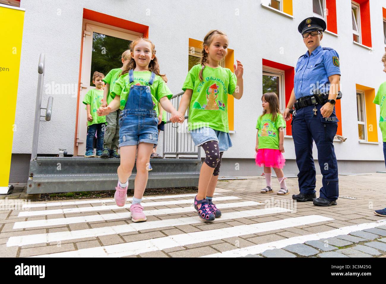 Presse- und Fototermin zur Verkehrssicherheit in der Kita Baumhaus die Dresdner Kita BAUMHAUS mit ihrem naturpädagogischen Schwerpunkt. Die gute Verkehrsanbindung birgt aber zum Teil komplexe Herausforderungen für die künftigen Schulkinder. Durch gezielte Übungen, Rollenspiele und gemeinsame Spaziergänge mit ihren Erzieherinnen und Erziehern können die Kinder ein Gefühl für sichere Verhaltensweisen im Straßenraum entwickeln. Einmal im Jahr bringen Bürgerpolizisten den Vorschulkindern die wichtigsten Verkehrsregeln auf spielerische Weise näher. Die Kinder wurden sensibilisiert, Gefahren m Stockfoto