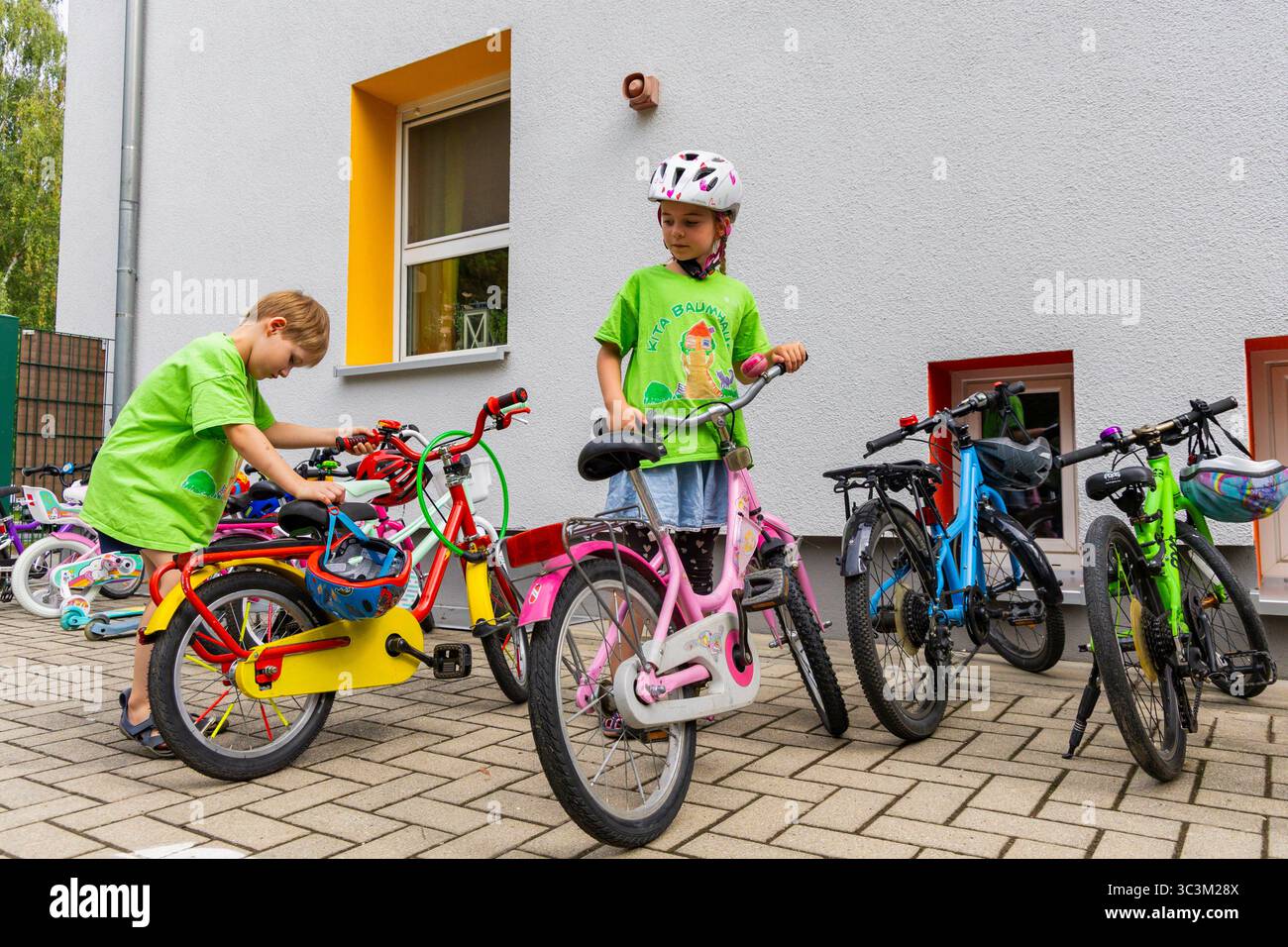 Presse- und Fototermin zur Verkehrssicherheit in der Kita Baumhaus die Dresdner Kita BAUMHAUS mit ihrem naturpädagogischen Schwerpunkt. Die gute Verkehrsanbindung birgt aber zum Teil komplexe Herausforderungen für die künftigen Schulkinder. Durch gezielte Übungen, Rollenspiele und gemeinsame Spaziergänge mit ihren Erzieherinnen und Erziehern können die Kinder ein Gefühl für sichere Verhaltensweisen im Straßenraum entwickeln. Einmal im Jahr bringen Bürgerpolizisten den Vorschulkindern die wichtigsten Verkehrsregeln auf spielerische Weise näher. Die Kinder wurden sensibilisiert, Gefahren m Stockfoto