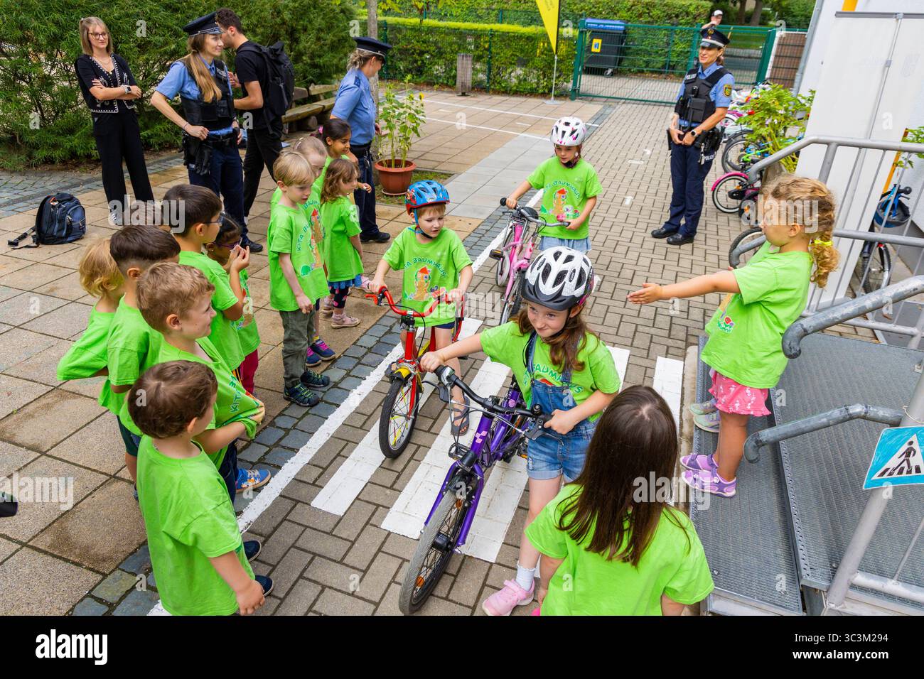 Presse- und Fototermin zur Verkehrssicherheit in der Kita Baumhaus die Dresdner Kita BAUMHAUS mit ihrem naturpädagogischen Schwerpunkt. Die gute Verkehrsanbindung birgt aber zum Teil komplexe Herausforderungen für die künftigen Schulkinder. Durch gezielte Übungen, Rollenspiele und gemeinsame Spaziergänge mit ihren Erzieherinnen und Erziehern können die Kinder ein Gefühl für sichere Verhaltensweisen im Straßenraum entwickeln. Einmal im Jahr bringen Bürgerpolizisten den Vorschulkindern die wichtigsten Verkehrsregeln auf spielerische Weise näher. Die Kinder wurden sensibilisiert, Gefahren m Stockfoto