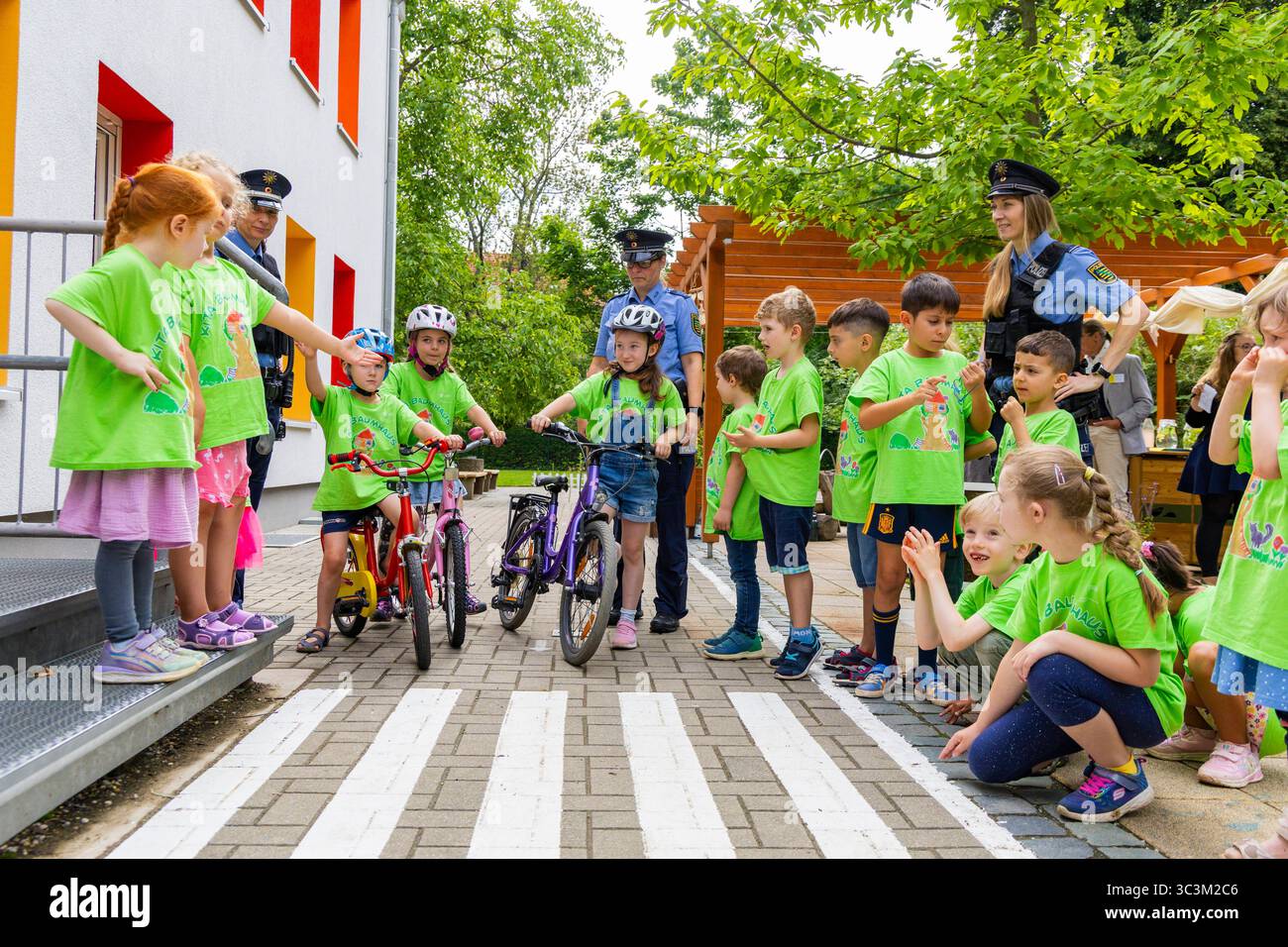 Presse- und Fototermin zur Verkehrssicherheit in der Kita Baumhaus die Dresdner Kita BAUMHAUS mit ihrem naturpädagogischen Schwerpunkt. Die gute Verkehrsanbindung birgt aber zum Teil komplexe Herausforderungen für die künftigen Schulkinder. Durch gezielte Übungen, Rollenspiele und gemeinsame Spaziergänge mit ihren Erzieherinnen und Erziehern können die Kinder ein Gefühl für sichere Verhaltensweisen im Straßenraum entwickeln. Einmal im Jahr bringen Bürgerpolizisten den Vorschulkindern die wichtigsten Verkehrsregeln auf spielerische Weise näher. Die Kinder wurden sensibilisiert, Gefahren m Stockfoto
