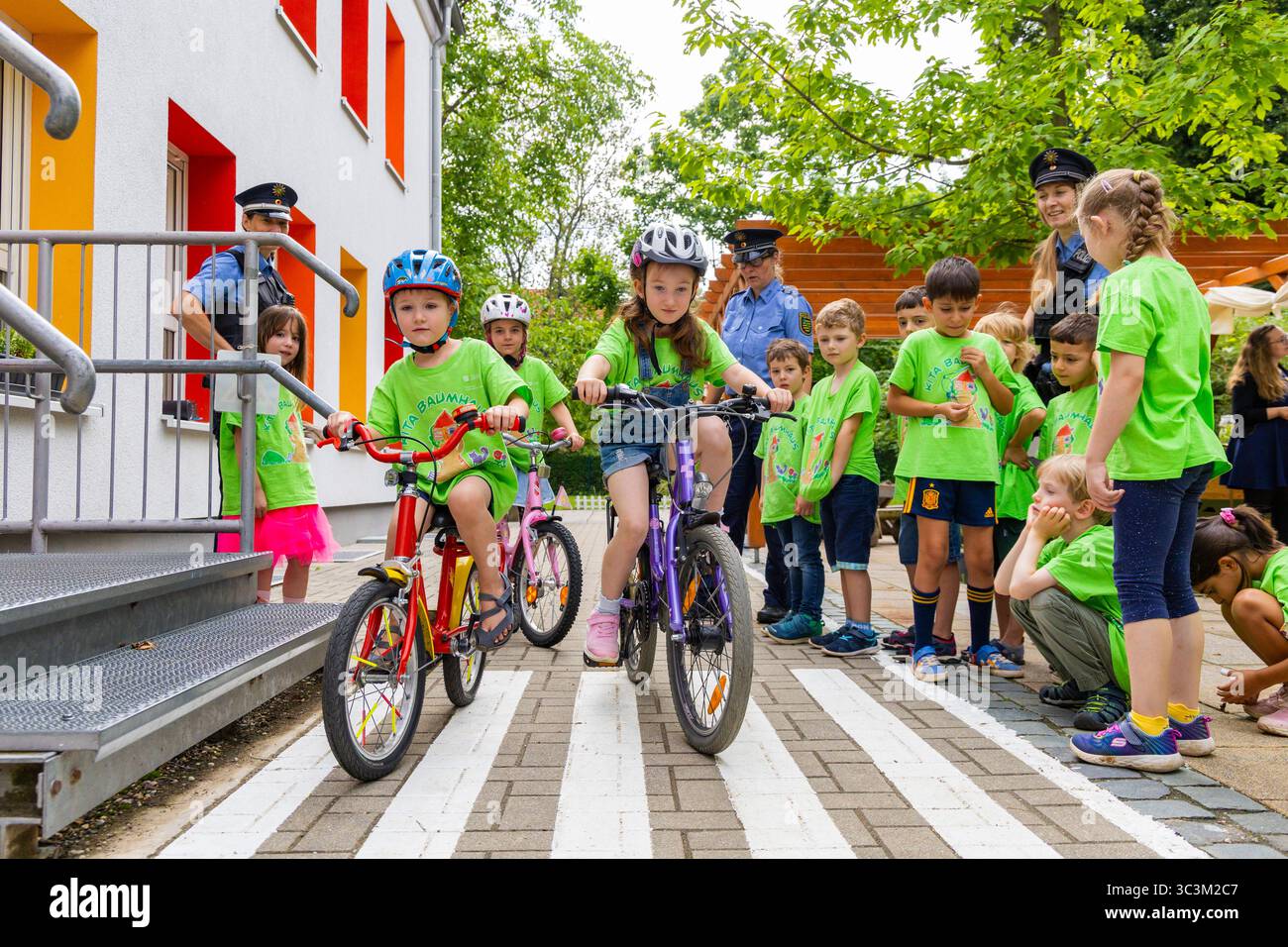 Presse- und Fototermin zur Verkehrssicherheit in der Kita Baumhaus die Dresdner Kita BAUMHAUS mit ihrem naturpädagogischen Schwerpunkt. Die gute Verkehrsanbindung birgt aber zum Teil komplexe Herausforderungen für die künftigen Schulkinder. Durch gezielte Übungen, Rollenspiele und gemeinsame Spaziergänge mit ihren Erzieherinnen und Erziehern können die Kinder ein Gefühl für sichere Verhaltensweisen im Straßenraum entwickeln. Einmal im Jahr bringen Bürgerpolizisten den Vorschulkindern die wichtigsten Verkehrsregeln auf spielerische Weise näher. Die Kinder wurden sensibilisiert, Gefahren m Stockfoto