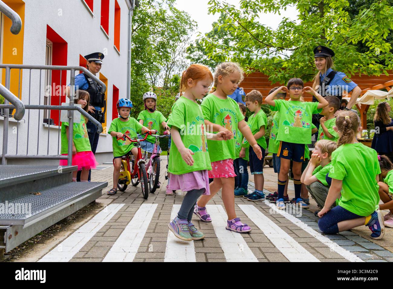 Presse- und Fototermin zur Verkehrssicherheit in der Kita Baumhaus die Dresdner Kita BAUMHAUS mit ihrem naturpädagogischen Schwerpunkt. Die gute Verkehrsanbindung birgt aber zum Teil komplexe Herausforderungen für die künftigen Schulkinder. Durch gezielte Übungen, Rollenspiele und gemeinsame Spaziergänge mit ihren Erzieherinnen und Erziehern können die Kinder ein Gefühl für sichere Verhaltensweisen im Straßenraum entwickeln. Einmal im Jahr bringen Bürgerpolizisten den Vorschulkindern die wichtigsten Verkehrsregeln auf spielerische Weise näher. Die Kinder wurden sensibilisiert, Gefahren m Stockfoto