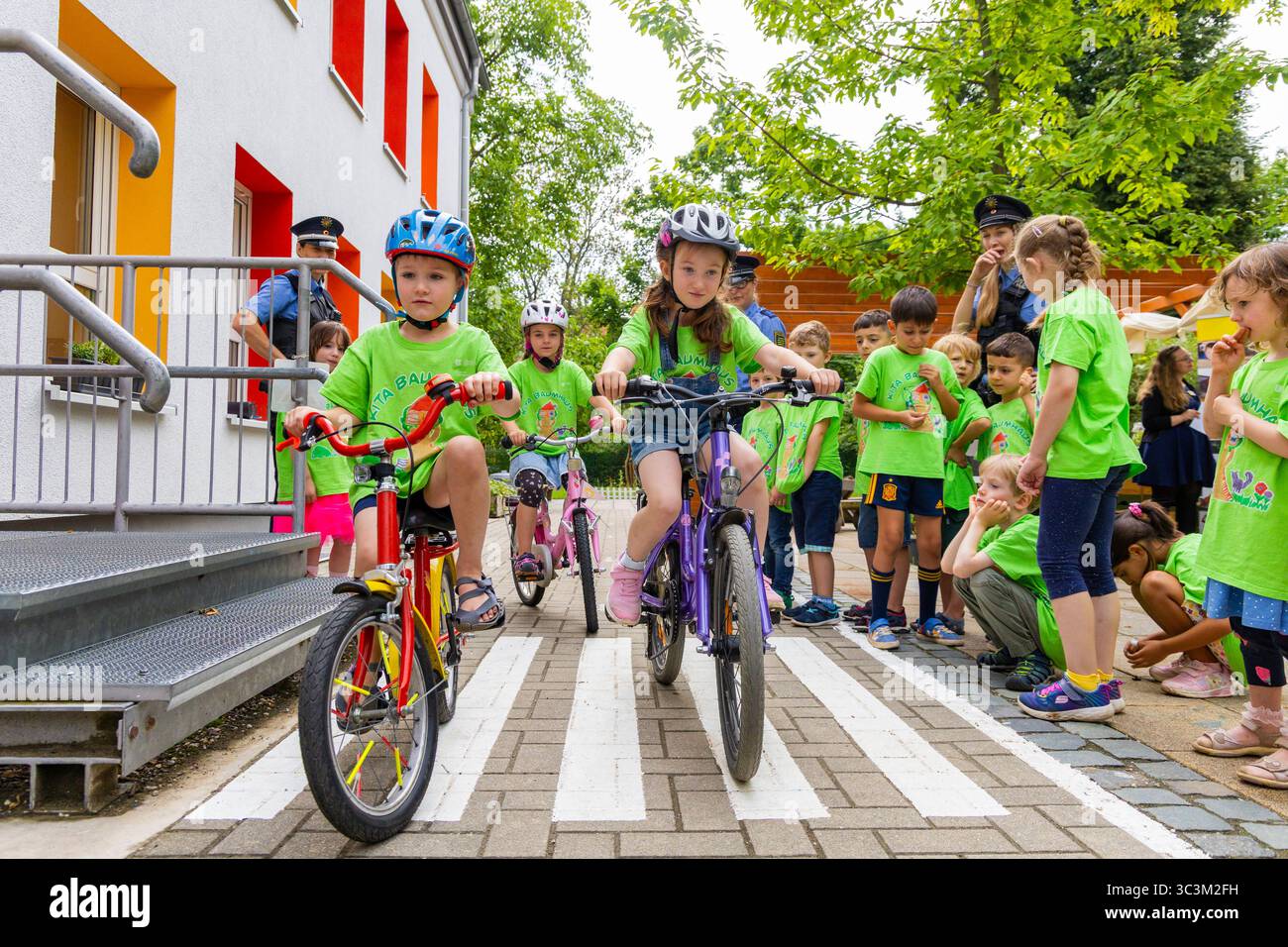 Presse- und Fototermin zur Verkehrssicherheit in der Kita Baumhaus die Dresdner Kita BAUMHAUS mit ihrem naturpädagogischen Schwerpunkt. Die gute Verkehrsanbindung birgt aber zum Teil komplexe Herausforderungen für die künftigen Schulkinder. Durch gezielte Übungen, Rollenspiele und gemeinsame Spaziergänge mit ihren Erzieherinnen und Erziehern können die Kinder ein Gefühl für sichere Verhaltensweisen im Straßenraum entwickeln. Einmal im Jahr bringen Bürgerpolizisten den Vorschulkindern die wichtigsten Verkehrsregeln auf spielerische Weise näher. Die Kinder wurden sensibilisiert, Gefahren m Stockfoto