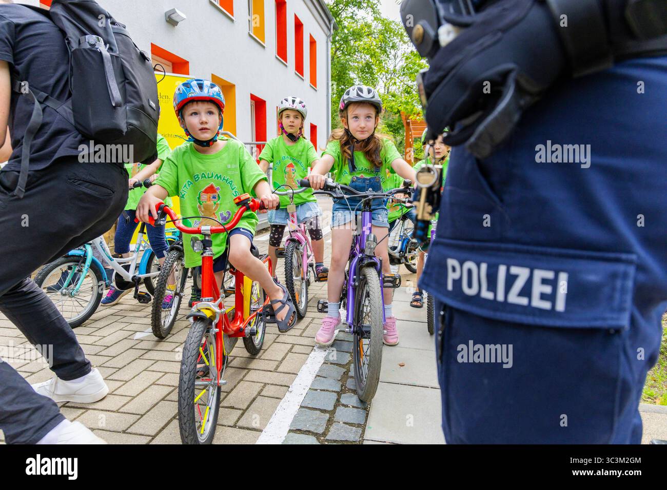 Presse- und Fototermin zur Verkehrssicherheit in der Kita Baumhaus die Dresdner Kita BAUMHAUS mit ihrem naturpädagogischen Schwerpunkt. Die gute Verkehrsanbindung birgt aber zum Teil komplexe Herausforderungen für die künftigen Schulkinder. Durch gezielte Übungen, Rollenspiele und gemeinsame Spaziergänge mit ihren Erzieherinnen und Erziehern können die Kinder ein Gefühl für sichere Verhaltensweisen im Straßenraum entwickeln. Einmal im Jahr bringen Bürgerpolizisten den Vorschulkindern die wichtigsten Verkehrsregeln auf spielerische Weise näher. Die Kinder wurden sensibilisiert, Gefahren m Stockfoto