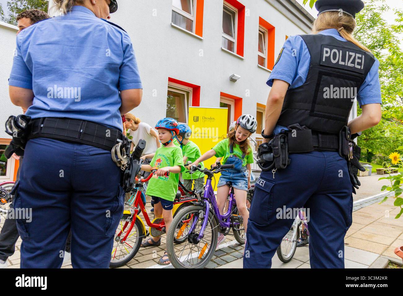 Presse- und Fototermin zur Verkehrssicherheit in der Kita Baumhaus die Dresdner Kita BAUMHAUS mit ihrem naturpädagogischen Schwerpunkt. Die gute Verkehrsanbindung birgt aber zum Teil komplexe Herausforderungen für die künftigen Schulkinder. Durch gezielte Übungen, Rollenspiele und gemeinsame Spaziergänge mit ihren Erzieherinnen und Erziehern können die Kinder ein Gefühl für sichere Verhaltensweisen im Straßenraum entwickeln. Einmal im Jahr bringen Bürgerpolizisten den Vorschulkindern die wichtigsten Verkehrsregeln auf spielerische Weise näher. Die Kinder wurden sensibilisiert, Gefahren m Stockfoto