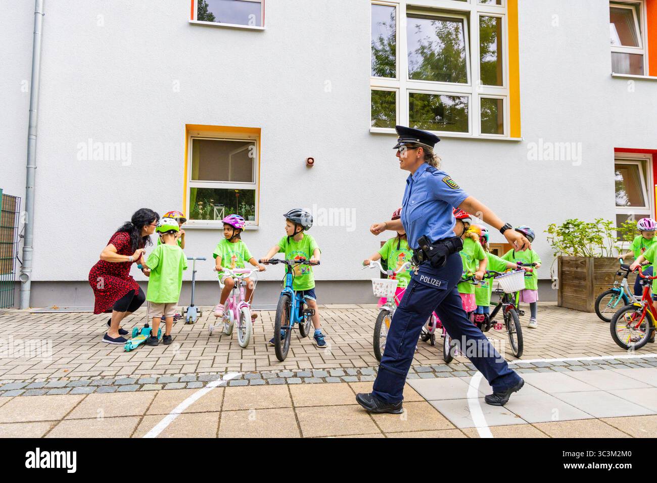 Presse- und Fototermin zur Verkehrssicherheit in der Kita Baumhaus die Dresdner Kita BAUMHAUS mit ihrem naturpädagogischen Schwerpunkt. Die gute Verkehrsanbindung birgt aber zum Teil komplexe Herausforderungen für die künftigen Schulkinder. Durch gezielte Übungen, Rollenspiele und gemeinsame Spaziergänge mit ihren Erzieherinnen und Erziehern können die Kinder ein Gefühl für sichere Verhaltensweisen im Straßenraum entwickeln. Einmal im Jahr bringen Bürgerpolizisten den Vorschulkindern die wichtigsten Verkehrsregeln auf spielerische Weise näher. Die Kinder wurden sensibilisiert, Gefahren m Stockfoto