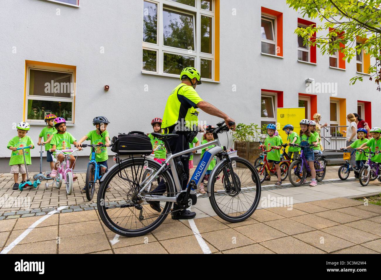 Presse- und Fototermin zur Verkehrssicherheit in der Kita Baumhaus die Dresdner Kita BAUMHAUS mit ihrem naturpädagogischen Schwerpunkt. Die gute Verkehrsanbindung birgt aber zum Teil komplexe Herausforderungen für die künftigen Schulkinder. Durch gezielte Übungen, Rollenspiele und gemeinsame Spaziergänge mit ihren Erzieherinnen und Erziehern können die Kinder ein Gefühl für sichere Verhaltensweisen im Straßenraum entwickeln. Einmal im Jahr bringen Bürgerpolizisten den Vorschulkindern die wichtigsten Verkehrsregeln auf spielerische Weise näher. Die Kinder wurden sensibilisiert, Gefahren m Stockfoto