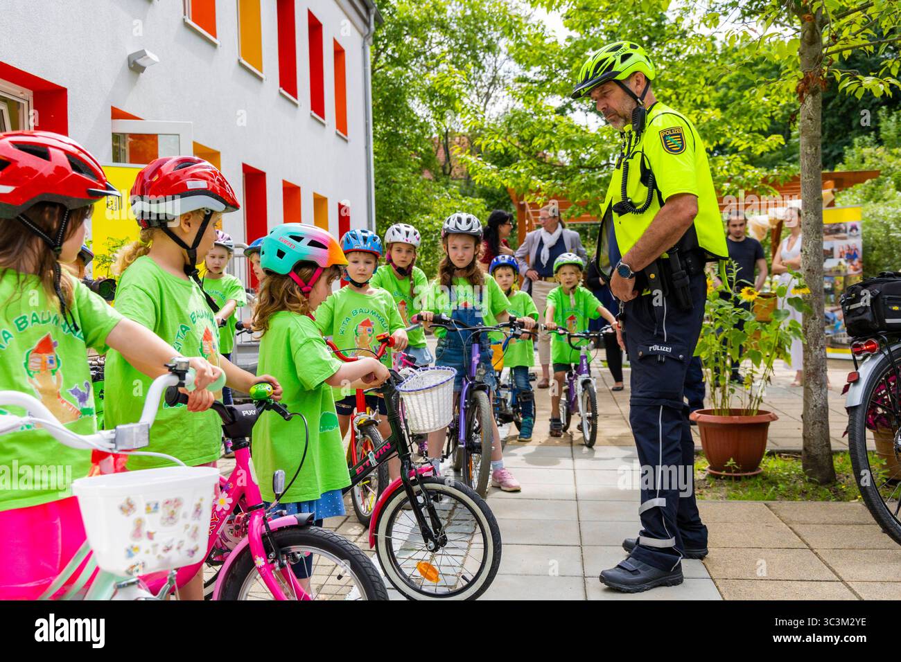 Presse- und Fototermin zur Verkehrssicherheit in der Kita Baumhaus die Dresdner Kita BAUMHAUS mit ihrem naturpädagogischen Schwerpunkt. Die gute Verkehrsanbindung birgt aber zum Teil komplexe Herausforderungen für die künftigen Schulkinder. Durch gezielte Übungen, Rollenspiele und gemeinsame Spaziergänge mit ihren Erzieherinnen und Erziehern können die Kinder ein Gefühl für sichere Verhaltensweisen im Straßenraum entwickeln. Einmal im Jahr bringen Bürgerpolizisten den Vorschulkindern die wichtigsten Verkehrsregeln auf spielerische Weise näher. Die Kinder wurden sensibilisiert, Gefahren m Stockfoto