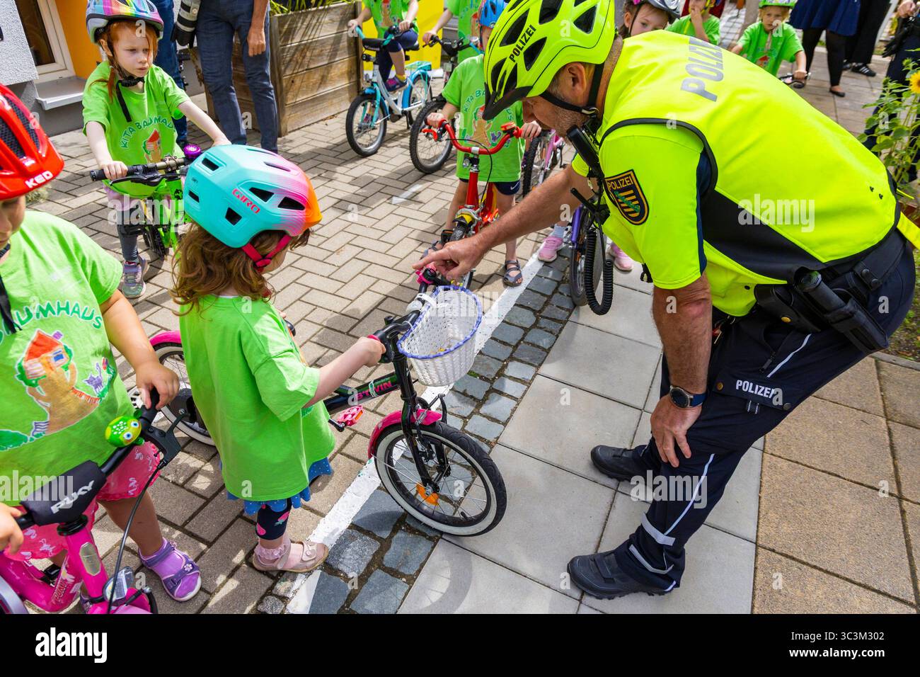 Presse- und Fototermin zur Verkehrssicherheit in der Kita Baumhaus die Dresdner Kita BAUMHAUS mit ihrem naturpädagogischen Schwerpunkt. Die gute Verkehrsanbindung birgt aber zum Teil komplexe Herausforderungen für die künftigen Schulkinder. Durch gezielte Übungen, Rollenspiele und gemeinsame Spaziergänge mit ihren Erzieherinnen und Erziehern können die Kinder ein Gefühl für sichere Verhaltensweisen im Straßenraum entwickeln. Einmal im Jahr bringen Bürgerpolizisten den Vorschulkindern die wichtigsten Verkehrsregeln auf spielerische Weise näher. Die Kinder wurden sensibilisiert, Gefahren m Stockfoto