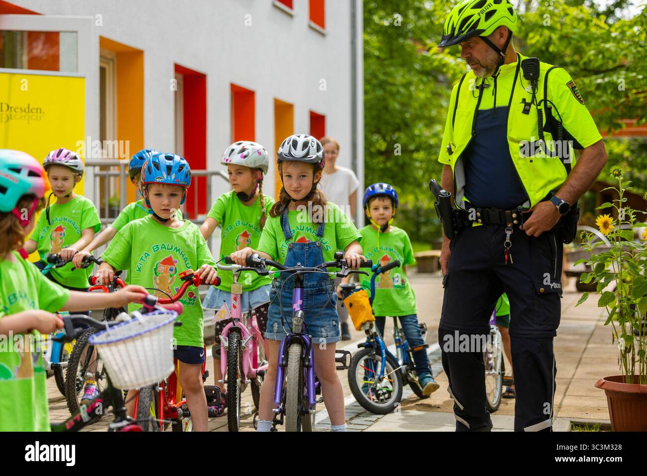 Presse- und Fototermin zur Verkehrssicherheit in der Kita Baumhaus die Dresdner Kita BAUMHAUS mit ihrem naturpädagogischen Schwerpunkt. Die gute Verkehrsanbindung birgt aber zum Teil komplexe Herausforderungen für die künftigen Schulkinder. Durch gezielte Übungen, Rollenspiele und gemeinsame Spaziergänge mit ihren Erzieherinnen und Erziehern können die Kinder ein Gefühl für sichere Verhaltensweisen im Straßenraum entwickeln. Einmal im Jahr bringen Bürgerpolizisten den Vorschulkindern die wichtigsten Verkehrsregeln auf spielerische Weise näher. Die Kinder wurden sensibilisiert, Gefahren m Stockfoto