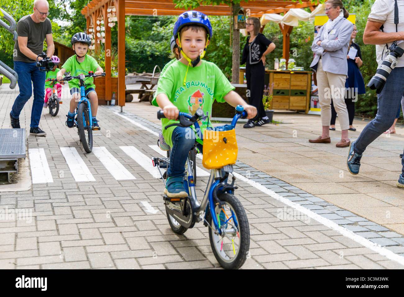 Presse- und Fototermin zur Verkehrssicherheit in der Kita Baumhaus die Dresdner Kita BAUMHAUS mit ihrem naturpädagogischen Schwerpunkt. Die gute Verkehrsanbindung birgt aber zum Teil komplexe Herausforderungen für die künftigen Schulkinder. Durch gezielte Übungen, Rollenspiele und gemeinsame Spaziergänge mit ihren Erzieherinnen und Erziehern können die Kinder ein Gefühl für sichere Verhaltensweisen im Straßenraum entwickeln. Einmal im Jahr bringen Bürgerpolizisten den Vorschulkindern die wichtigsten Verkehrsregeln auf spielerische Weise näher. Die Kinder wurden sensibilisiert, Gefahren m Stockfoto