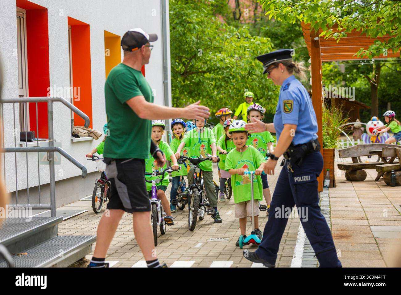 Presse- und Fototermin zur Verkehrssicherheit in der Kita Baumhaus die Dresdner Kita BAUMHAUS mit ihrem naturpädagogischen Schwerpunkt. Die gute Verkehrsanbindung birgt aber zum Teil komplexe Herausforderungen für die künftigen Schulkinder. Durch gezielte Übungen, Rollenspiele und gemeinsame Spaziergänge mit ihren Erzieherinnen und Erziehern können die Kinder ein Gefühl für sichere Verhaltensweisen im Straßenraum entwickeln. Einmal im Jahr bringen Bürgerpolizisten den Vorschulkindern die wichtigsten Verkehrsregeln auf spielerische Weise näher. Die Kinder wurden sensibilisiert, Gefahren m Stockfoto