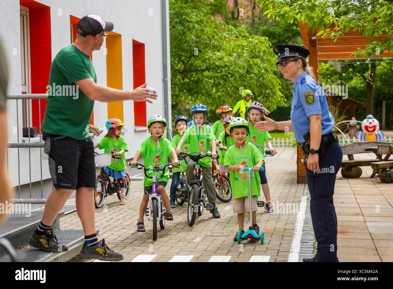 Presse- und Fototermin zur Verkehrssicherheit in der Kita Baumhaus die Dresdner Kita BAUMHAUS mit ihrem naturpädagogischen Schwerpunkt. Die gute Verkehrsanbindung birgt aber zum Teil komplexe Herausforderungen für die künftigen Schulkinder. Durch gezielte Übungen, Rollenspiele und gemeinsame Spaziergänge mit ihren Erzieherinnen und Erziehern können die Kinder ein Gefühl für sichere Verhaltensweisen im Straßenraum entwickeln. Einmal im Jahr bringen Bürgerpolizisten den Vorschulkindern die wichtigsten Verkehrsregeln auf spielerische Weise näher. Die Kinder wurden sensibilisiert, Gefahren m Stockfoto