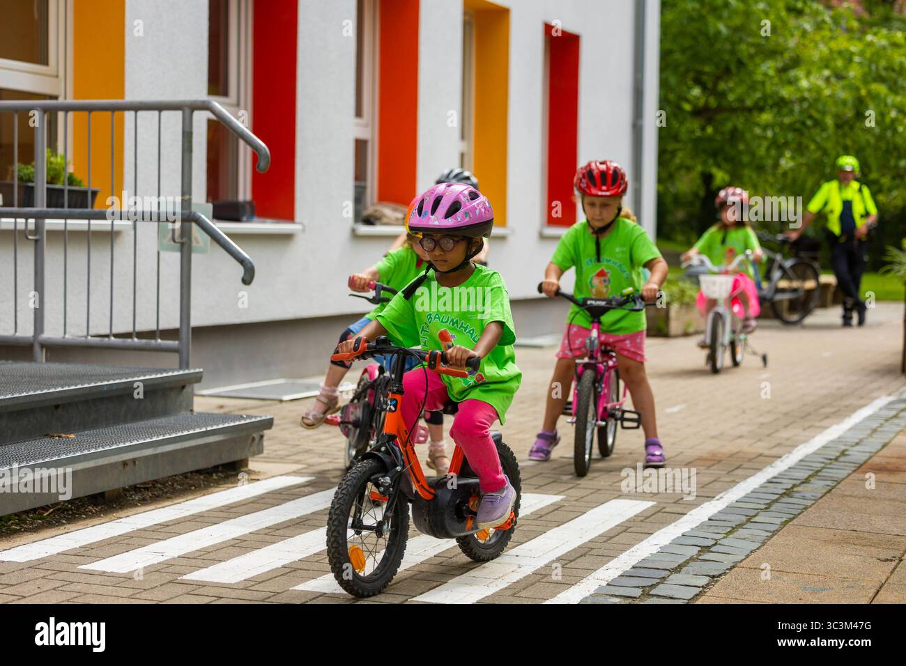 Presse- und Fototermin zur Verkehrssicherheit in der Kita Baumhaus die Dresdner Kita BAUMHAUS mit ihrem naturpädagogischen Schwerpunkt. Die gute Verkehrsanbindung birgt aber zum Teil komplexe Herausforderungen für die künftigen Schulkinder. Durch gezielte Übungen, Rollenspiele und gemeinsame Spaziergänge mit ihren Erzieherinnen und Erziehern können die Kinder ein Gefühl für sichere Verhaltensweisen im Straßenraum entwickeln. Einmal im Jahr bringen Bürgerpolizisten den Vorschulkindern die wichtigsten Verkehrsregeln auf spielerische Weise näher. Die Kinder wurden sensibilisiert, Gefahren m Stockfoto