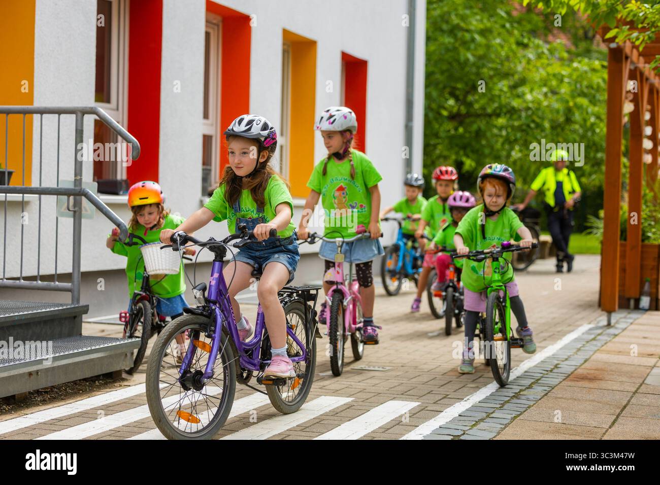 Presse- und Fototermin zur Verkehrssicherheit in der Kita Baumhaus die Dresdner Kita BAUMHAUS mit ihrem naturpädagogischen Schwerpunkt. Die gute Verkehrsanbindung birgt aber zum Teil komplexe Herausforderungen für die künftigen Schulkinder. Durch gezielte Übungen, Rollenspiele und gemeinsame Spaziergänge mit ihren Erzieherinnen und Erziehern können die Kinder ein Gefühl für sichere Verhaltensweisen im Straßenraum entwickeln. Einmal im Jahr bringen Bürgerpolizisten den Vorschulkindern die wichtigsten Verkehrsregeln auf spielerische Weise näher. Die Kinder wurden sensibilisiert, Gefahren m Stockfoto
