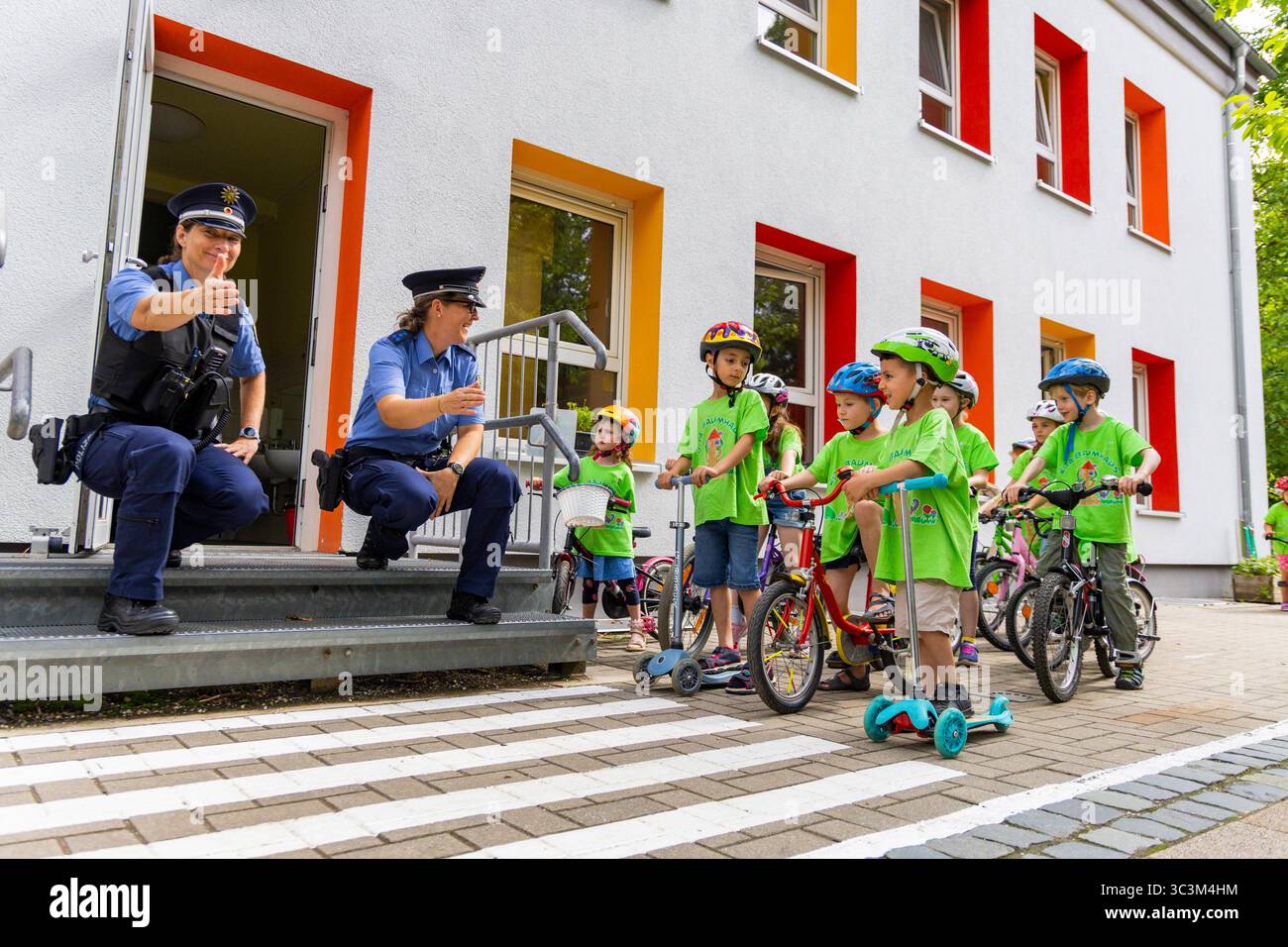Presse- und Fototermin zur Verkehrssicherheit in der Kita Baumhaus die Dresdner Kita BAUMHAUS mit ihrem naturpädagogischen Schwerpunkt. Die gute Verkehrsanbindung birgt aber zum Teil komplexe Herausforderungen für die künftigen Schulkinder. Durch gezielte Übungen, Rollenspiele und gemeinsame Spaziergänge mit ihren Erzieherinnen und Erziehern können die Kinder ein Gefühl für sichere Verhaltensweisen im Straßenraum entwickeln. Einmal im Jahr bringen Bürgerpolizisten den Vorschulkindern die wichtigsten Verkehrsregeln auf spielerische Weise näher. Die Kinder wurden sensibilisiert, Gefahren m Stockfoto