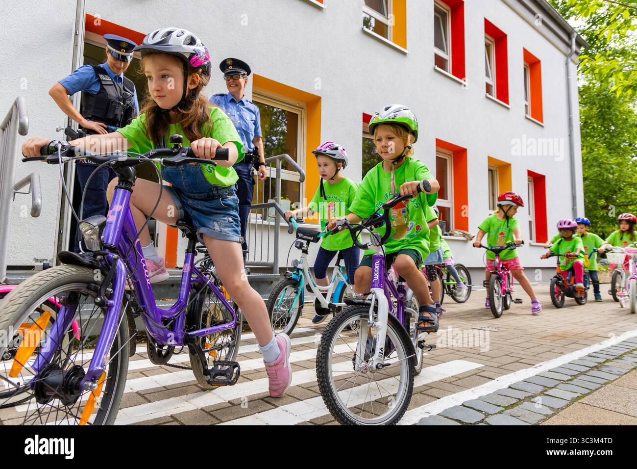 Presse- und Fototermin zur Verkehrssicherheit in der Kita Baumhaus die Dresdner Kita BAUMHAUS mit ihrem naturpädagogischen Schwerpunkt. Die gute Verkehrsanbindung birgt aber zum Teil komplexe Herausforderungen für die künftigen Schulkinder. Durch gezielte Übungen, Rollenspiele und gemeinsame Spaziergänge mit ihren Erzieherinnen und Erziehern können die Kinder ein Gefühl für sichere Verhaltensweisen im Straßenraum entwickeln. Einmal im Jahr bringen Bürgerpolizisten den Vorschulkindern die wichtigsten Verkehrsregeln auf spielerische Weise näher. Die Kinder wurden sensibilisiert, Gefahren m Stockfoto
