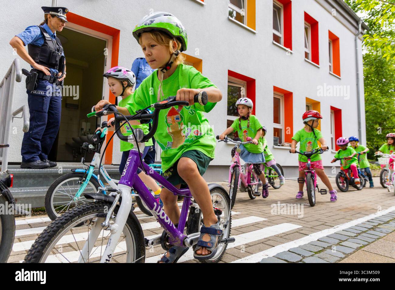 Presse- und Fototermin zur Verkehrssicherheit in der Kita Baumhaus die Dresdner Kita BAUMHAUS mit ihrem naturpädagogischen Schwerpunkt. Die gute Verkehrsanbindung birgt aber zum Teil komplexe Herausforderungen für die künftigen Schulkinder. Durch gezielte Übungen, Rollenspiele und gemeinsame Spaziergänge mit ihren Erzieherinnen und Erziehern können die Kinder ein Gefühl für sichere Verhaltensweisen im Straßenraum entwickeln. Einmal im Jahr bringen Bürgerpolizisten den Vorschulkindern die wichtigsten Verkehrsregeln auf spielerische Weise näher. Die Kinder wurden sensibilisiert, Gefahren m Stockfoto